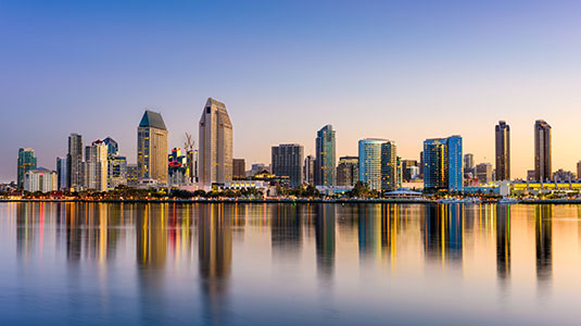 The image depicts high rise building and its reflection showing in water to showcase second day  AFP conference, Pelican’s Innovation Hub