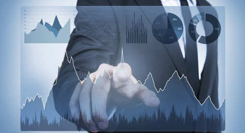 The image depicts a man going through various charts  and graphs like bar graph and pie chart to analysis trends of TBML.